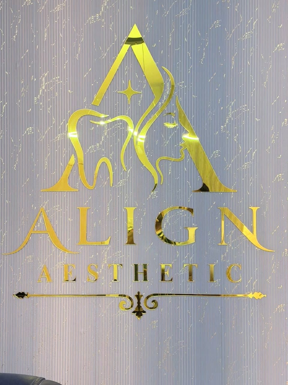 Gold Align Aesthetic logo on the consultation room wall