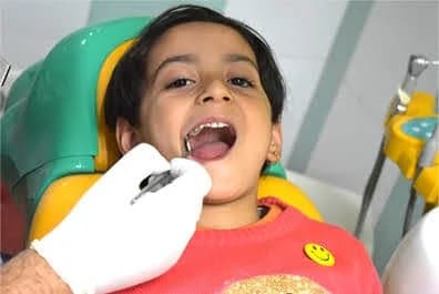 A young child smiling in the dental chair during a gentle check-up